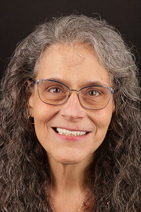 Patient showcasing a radiant smile after complete smile reconstruction with veneers and crowns.
